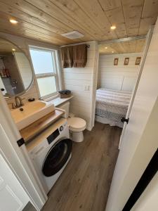 a small bathroom with a sink and a washing machine at Mountain View Retreat in Creston +3 photos