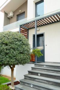 a house with stairs leading to the front door at Modern house! in Iráklia