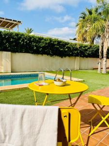 a yellow table with a bowl on it next to a pool at Lancón Boutique- Precioso apartamento a 150 m a pie de playa Lancón- Carboneras in Carboneras