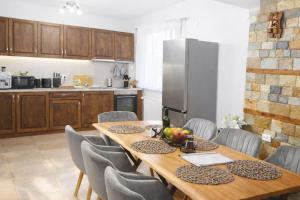 a kitchen with a wooden table with chairs and a refrigerator at Къща за гости Брязово in Ribarica