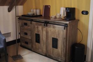 ein Holzschrank mit einer Kaffeemaschine darauf in der Unterkunft De Jagersloft in Wedde