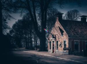 ein kleines Backsteinhaus mit einer Flagge darauf in der Unterkunft De Jagersloft in Wedde