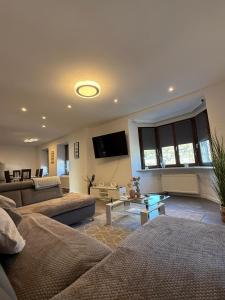 a living room with two couches and a flat screen tv at Adiferienwohnung1 in Gerolstein