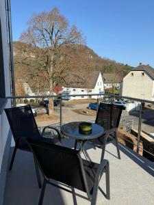 two chairs and a table on a balcony with a view at Adiferienwohnung1 in Gerolstein +7 photos