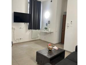 a living room with a coffee table and a flat screen tv at Fiore Apartments in Fiorenzuola dʼArda