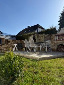 a patio with chairs and a table and a stone wall at Adiferienwohnung1 in Gerolstein