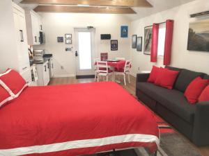 a living room with a red bed and a couch at Garden Guest Cottage in Harrisonburg