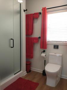 a bathroom with a toilet and red towels at Garden Guest Cottage in Harrisonburg