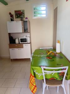 a kitchen with a table with a green table cloth at Villa Zaboka in Baillif