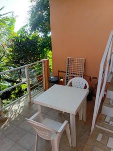 a white table and chairs on a balcony at Villa Zaboka in Baillif