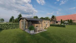a small house with a table and chairs in a yard at Minicamping Ons Weitje in Koudekerke