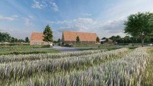 a field of grass with houses in the background at Minicamping Ons Weitje in Koudekerke