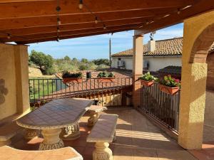 a patio with a table and benches on a balcony at Casa Marèlia, Costa Daurada Rural in Vilanova de Escornalbou