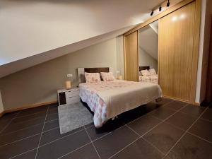 a bedroom with a bed and a large mirror at Aldea Bricia 16 in Posada de Llanes