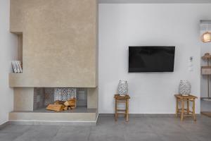 a living room with a fireplace with a flat screen tv at Villa Pastida - Boutique Luxury Villa on Rhodes with Private Pool in Pastida