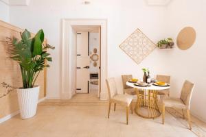 a dining room with a table and chairs and a plant at Corina Secret Rooms in Martano