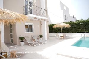 a patio with chairs and a swimming pool and a building at Villa Pastida - Boutique Luxury Villa on Rhodes with Private Pool in Pastida