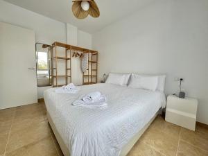 a bedroom with a white bed with towels on it at Lancón Boutique- Precioso apartamento a 150 m a pie de playa Lancón- Carboneras in Carboneras +27 photos