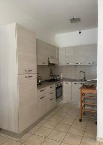 a kitchen with white cabinets and a table in it at Il Giardino di Luna in Poggio Nativo