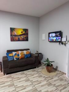 a living room with a couch and a flat screen tv at Casa Solmar Guriú in Guriú