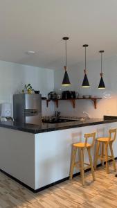 a kitchen with a counter and two stools at Casa Solmar Guriú in Guriú