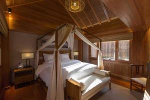 a bedroom with a canopy bed and a window at 见天会馆 in Lijiang