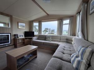 a living room with a couch and a tv at Glasyln 37 in Porthmadog