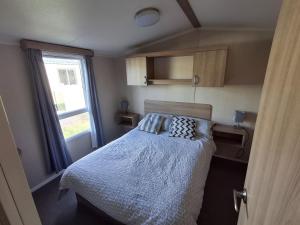 a small bedroom with a bed and a window at Glasyln 37 in Porthmadog +1 photo