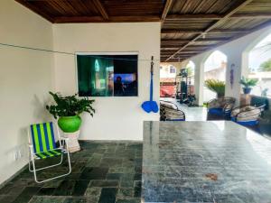 a living room with a table and a chair at Casa com Piscina Grande em Salinas in Salinópolis