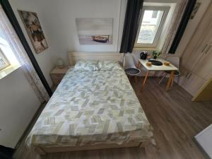 a bedroom with a large bed and a table at Apartman Stari grad, Budva in Budva +2 photos