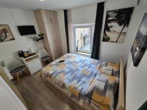 a bedroom with a bed and a desk and a window at Apartman Stari grad, Budva in Budva