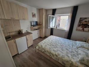 a small bedroom with a bed and a kitchen at Apartman Stari grad, Budva in Budva