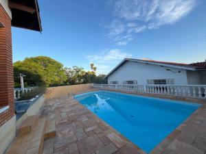 a swimming pool in the backyard of a house at Quarto triplo - Casa Azul - Águas de São Pedro in Águas de São Pedro