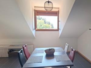 a dining room with a table and chairs and a window at Aldea Bricia 16 in Posada de Llanes +10 photos