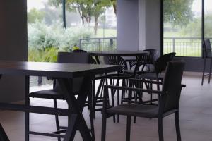 a row of tables and chairs in a restaurant at The Millennial, Secure parking, 3 mins to Gateway in Durban