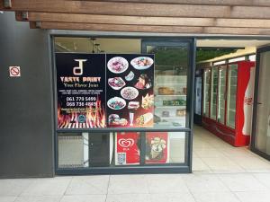a restaurant with a sign in the window of a store at The Millennial, Secure parking, 3 mins to Gateway in Durban