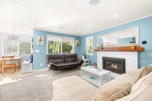 a living room with a couch and a fireplace at Bright Beach Town Bungalow in Gleneden Beach