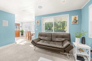 a leather couch in a living room with blue walls at Bright Beach Town Bungalow in Gleneden Beach