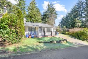 a house with a porch on the side of the road at Bright Beach Town Bungalow in Gleneden Beach
