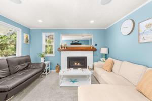 a living room with a couch and a fireplace at Bright Beach Town Bungalow in Gleneden Beach +20 photos