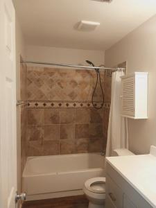 a bathroom with a tub and a toilet and a sink at The Elect at Pinewood in Millbrook