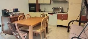 a kitchen with a wooden table and chairs in a kitchen at Colonne Blu in Ginosa Marina