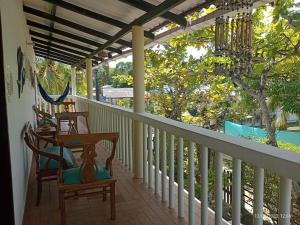 a porch with two chairs and a chandelier at Cabanas Recreaciones in Coveñas