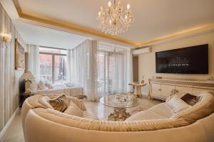a living room with a couch and a chandelier at Waterlane Riverside - SPA, Pool, Gym & Parking by Downtown Apartments in Gdańsk