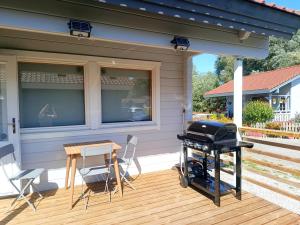 a patio with a grill and a table and chairs at "Kota coeur de bois" Chalet en bois au domaine de l'Aa in Bourbourg