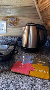 a tea kettle and a book on a counter at Chalé Serra Furada - vista única da Serra Furada in Grão Pará