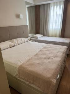 two beds sitting next to each other in a bedroom at Hotel Treviso suítes in Linhares