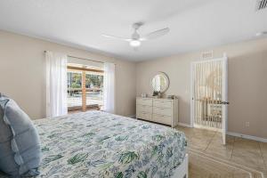 a bedroom with a bed and a window at Sip of Sun in New Smyrna Beach