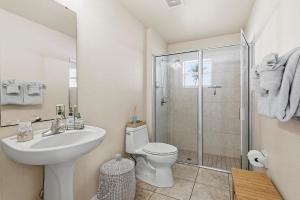 a bathroom with a toilet and a sink and a shower at Sip of Sun in New Smyrna Beach +55 photos