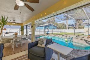 a house with a swimming pool with a table and chairs at Sip of Sun in New Smyrna Beach